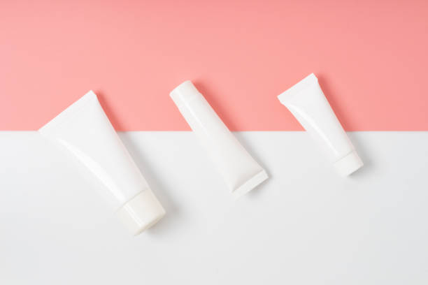 istock white cream tubes on light on pink background 1266591253