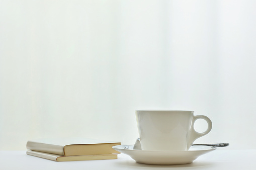 a cup of coffee & books by the window with natural light.