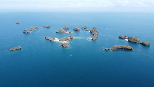 Distant Aerial of Hundred Islands and Lingayen Gulf in Alaminos, Pangasinan, Philippines. It is a national park and a protected area. Distant Aerial of Hundred Islands and Lingayen Gulf in Alaminos, Pangasinan, Philippines. It is a national park and a protected area. Drone shot. pangasinan stock pictures, royalty-free photos & images