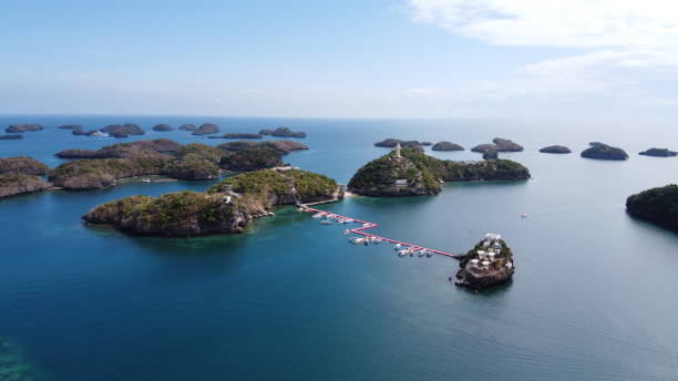 Aerial of Pilgrimage and Ramos Island, part of Hundred Islands in Alaminos, Pangasinan, Philippines. Visible is a red floating deck with many boats. Aerial of Pilgrimage and Ramos Island, part of Hundred Islands in Alaminos, Pangasinan, Philippines. Visible is a red floating deck with many boats. pangasinan stock pictures, royalty-free photos & images
