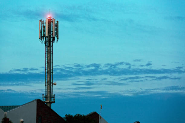 우울한 새벽 하늘에 대한 공장 지붕 위에 휴대 전화 기지국 타워 - 4g 뉴스 사진 이미지
