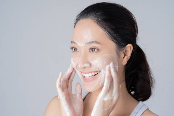 beautiful female asian wash face with cleansing foam. in studio - exfoliating scrub imagens e fotografias de stock