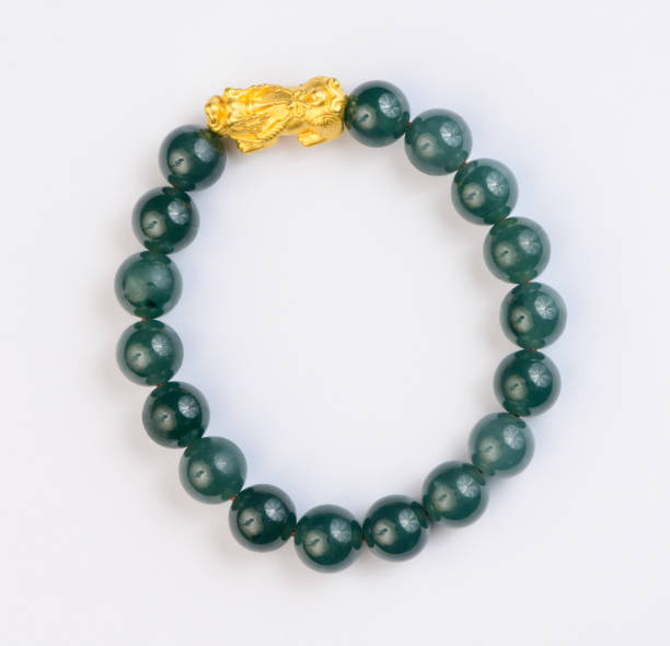 Green jade bracelet on white background Green jade bracelet on white background. gold and green  jade bracelet stock pictures, royalty-free photos & images