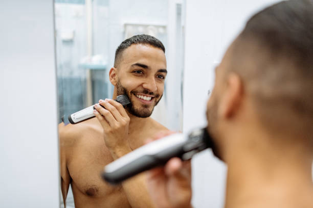 istock Latino man shaving in front of the mirror 1266616561