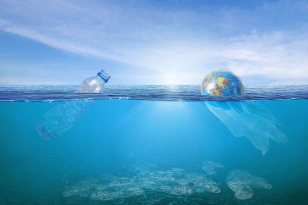 istock Creative background, World wrapped in plastic floating in the ocean, a bottle in the water. 1266616705