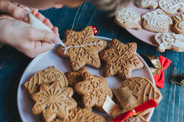 istock Boy is decorating gingerbread cookies with icing sugar. Snowflake, star shapes. 1266618118