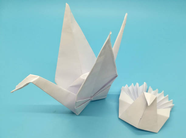 istock Origami figures made with white paper on blue background 1266620965