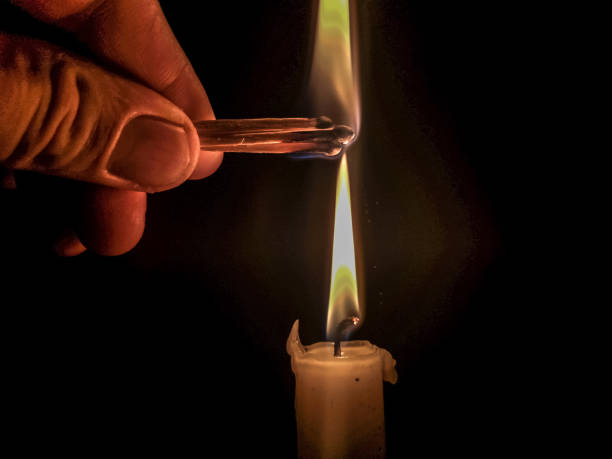 istock Matches burning to light a candle on black background 1266624485