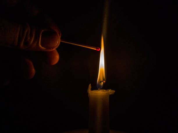 istock Matches burning to light a candle on black background 1266625191