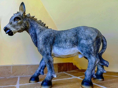 Ceramic figure of a donkey with yellow background