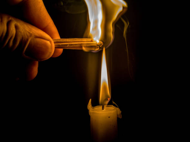 istock Matches burning to light a candle on black background 1266625786