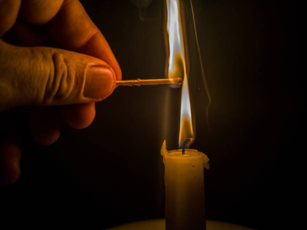 istock Matches burning to light a candle on black background 1266626082