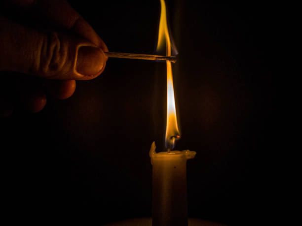 istock Matches burning to light a candle on black background 1266626298