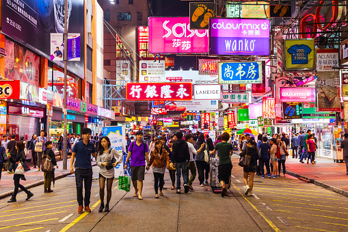 HONG KONG - MARCH 19, 2013: Unidentified people and signboards with neon light advertisement on Mongkok pedestrian shopping street in Hong Kong at night.