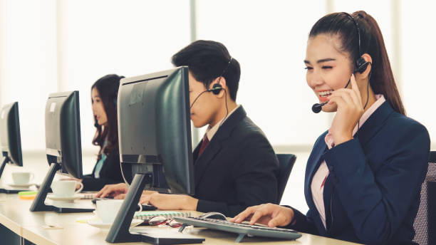istock Business people wearing headset working in office 1266629394
