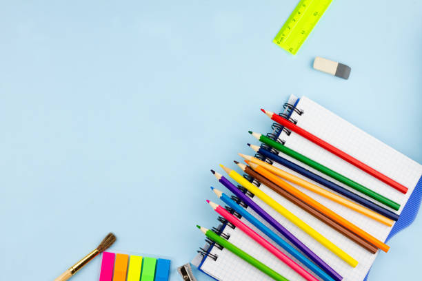 istock Pencils lie on a notebook on a blue background. 1266632180