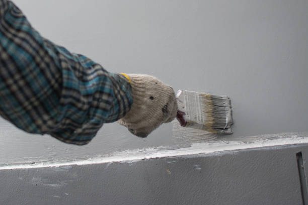 istock Man painting wall with gray color 1266634362