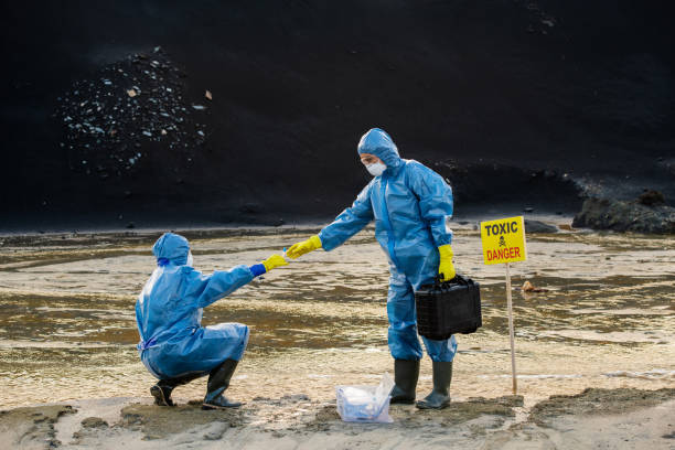 istock Young ecologist in protective workwear taking flask with sample of water 1266639473