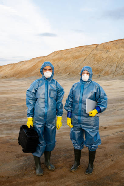 istock Two young female researchers in protective workwear standing on polluted soil 1266639477