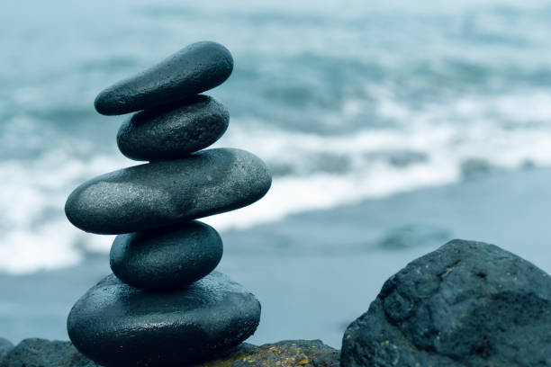 balancing stones arranged in a pyramid shape - balance simplicity nature beach imagens e fotografias de stock