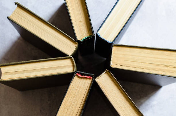 istock Books with multi-colored covers are stacked in a circle top view. 1266643425