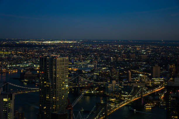 skyline view of skyscrapers at night of downtown manhattan, brooklyn and connecting bridges - connection usa brooklyn bridge business imagens e fotografias de stock