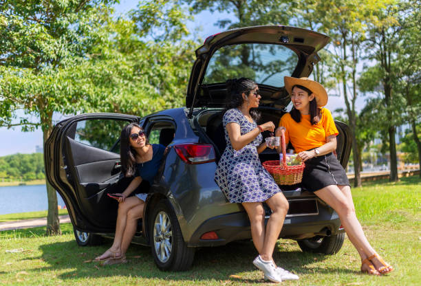 istock female friends having fun and talking by the car 1266645822