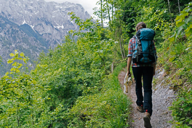 istock Young woman walks along a narrow path in the mountains 1266645949