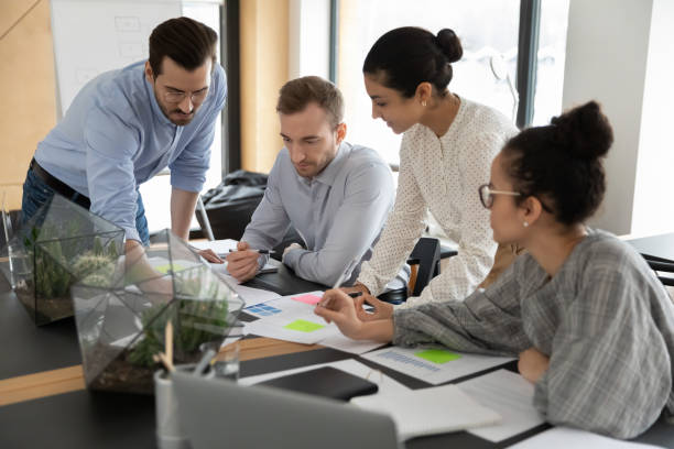 istock Focused multiracial employee discuss company documents at meeting 1266648533