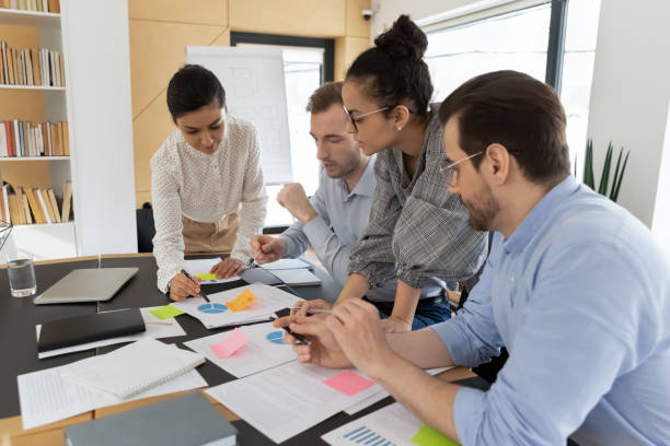 istock Multiracial employees brainstorm discussing paperwork at meeting 1266648534