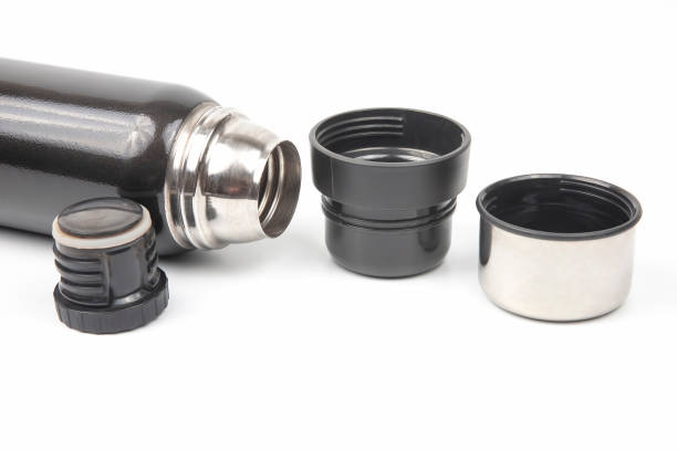 a stainless steel thermos bottle and a vacuum tumbler on red at horizontal composition