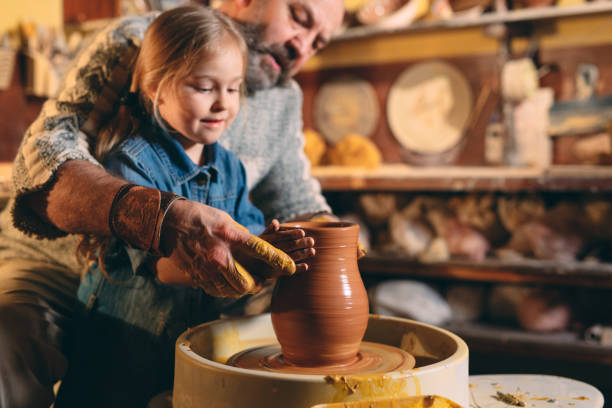 istock Pottery workshop. Grandpa teaches granddaughter pottery. Clay modeling 1266650893