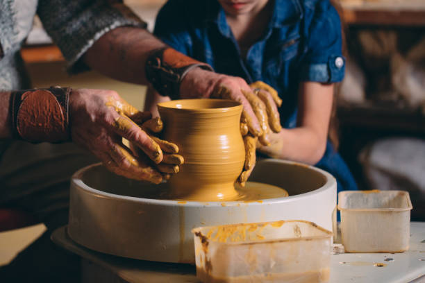 istock Pottery workshop. Grandpa teaches granddaughter pottery. Clay modeling 1266651045