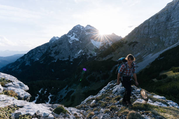 istock Young woman hikes along a mountain ridge with a bug net at sunrise 1266652229