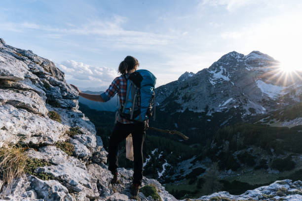 istock Young woman hikes along a mountain ridge with a bug net at sunrise 1266653597