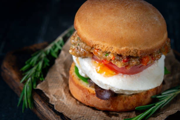 istock Vegetable homemade Burger made from fried eggplant, tomato, lettuce avocado and mozzarella cheese on a wooden Board. 1266656119