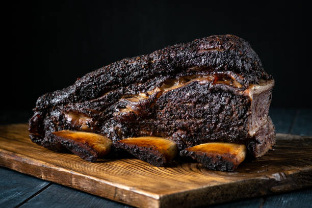A large piece of smoked beef brisket on the ribs with a dark crust. Classic Texas BBQ A large piece of smoked beef brisket on the ribs with a dark crust. Classic Texas BBQ smoked pork stock pictures, royalty-free photos & images