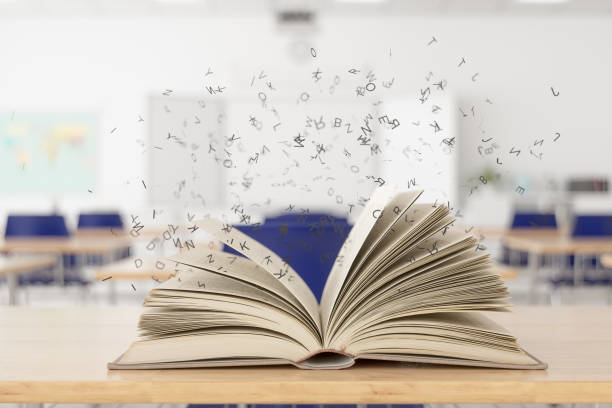 Open Magical Book On Desk In Classroom.