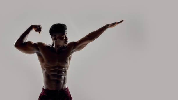 istock Strength inside and out. Young muscular african american bodybuilder looking aside, posing shirtless isolated over grey background. Sports, workout, bodybuilding concept 1266658762