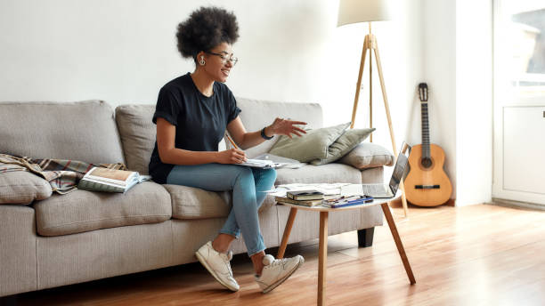 Improving drawing skills. Happy afro american woman explaining something while teaching to draw trough web camera at home, giving online lesson