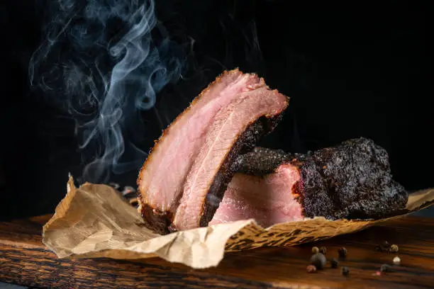 Sliced smoked beef brisket with dark crust from classic Texas BBQ smokehouse