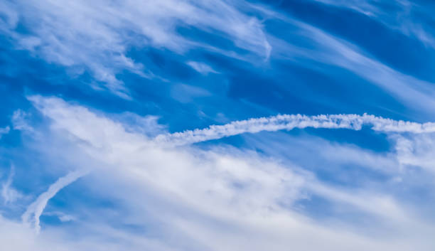istock Aircraft condensation contrails in the blue sky inbetween some clouds 1266666230