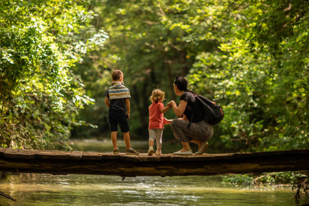 istock Family crossing footpath bridge in forest 1266666785