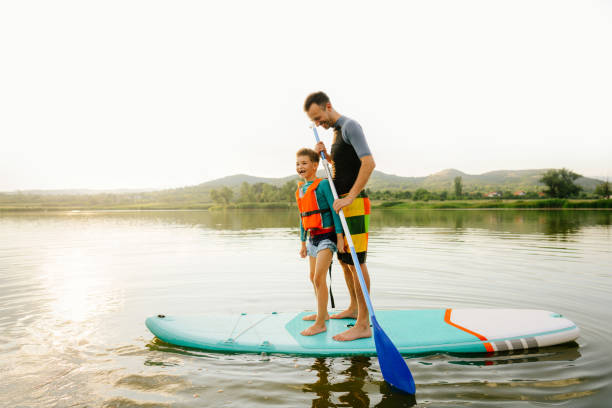 istock Father and son paddleboarding on a lake 1266667045