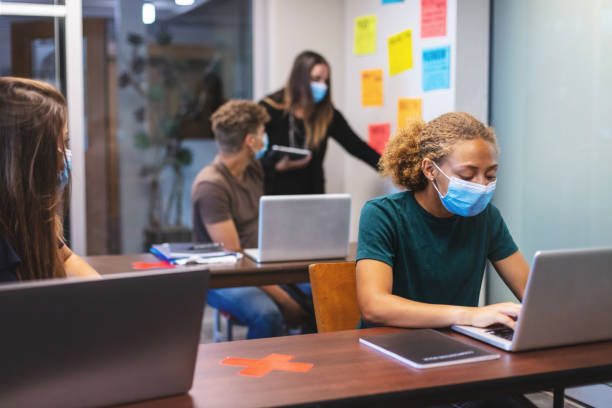 istock Female High School Student in Classroom Setting Wearing Mask 1266667770
