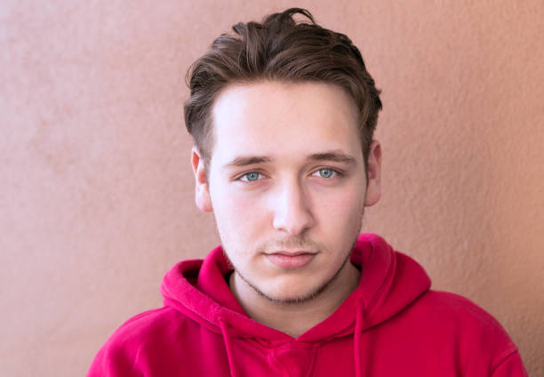 Young, preteen boy looks at the camera with a serious expression.