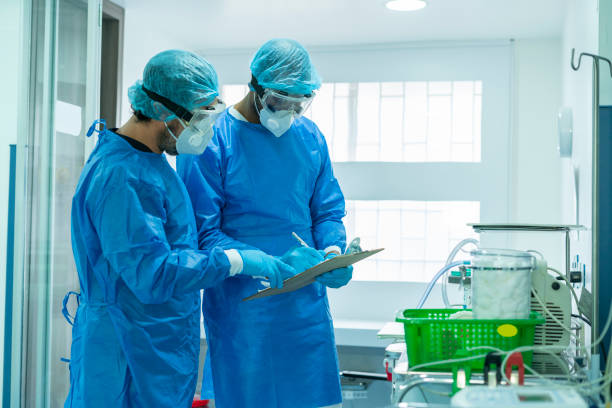 istock 2 doctors check the Intensive Care machines while wearing their high security suits 1266669734