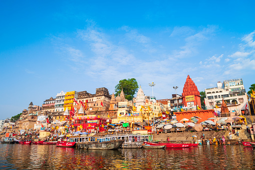 VARANASI, INDIA - APRIL 12, 2012: Colorful boats and Ganges river bank in Varanasi city in India