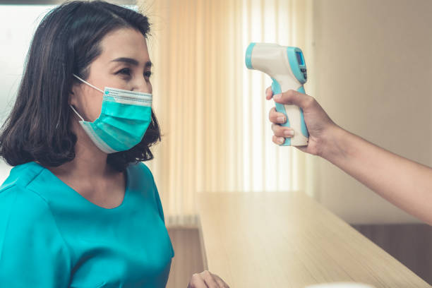 istock Receptionist and guest wearing face mask at front desk . 1266681990