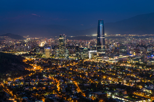 Panoramic view of Santiago cityscape including modern buildings in the financial district at night in Chile, South America.
